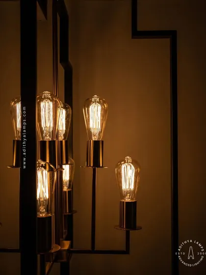 Inspired by Art Deco design, this hanging fixture features a strong geometric black frame with exposed vintage-style filament bulbs. The combination of black and warm gold tones provides a sophisticated, retro feel for dining areas or entryways.