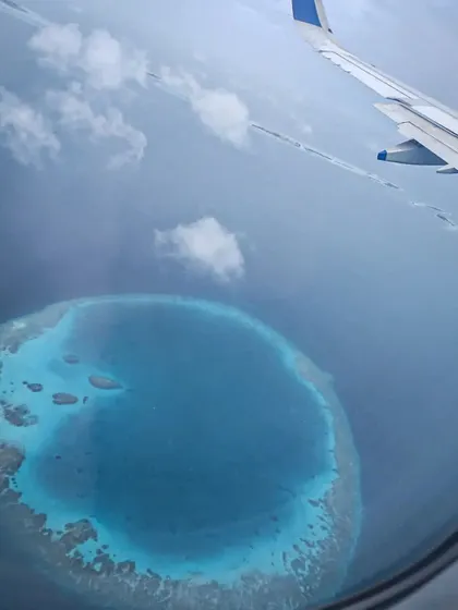 A stunning view of a circular atoll from the air as we approach the Maldives. These unique coral formations create the calm lagoons and rich channel dives that make the area so special.