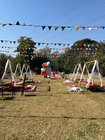A wide view of our picnic-style birthday setup, with individual teepees and low tables spread across the lawn for a relaxed gathering.