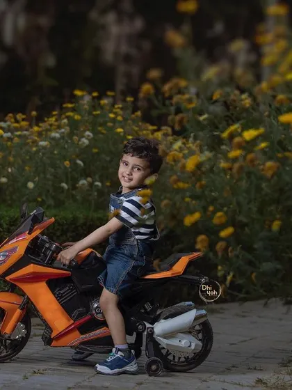 Another wonderful shot from our outdoor bike ride session. The warm sunlight filtering through the flowers creates a magical atmosphere as this little adventurer enjoys his ride.