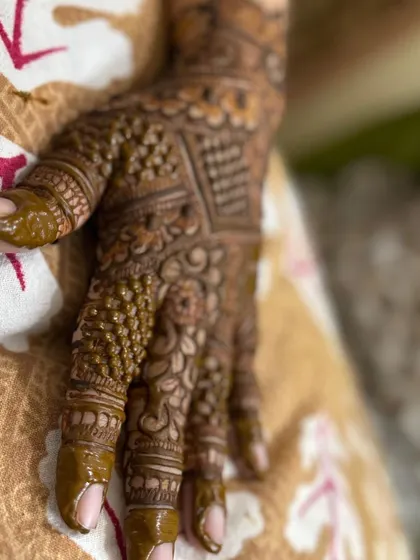 A close-up of a very dense Indian back-hand design, filled with geometric blocks and fine-line details.