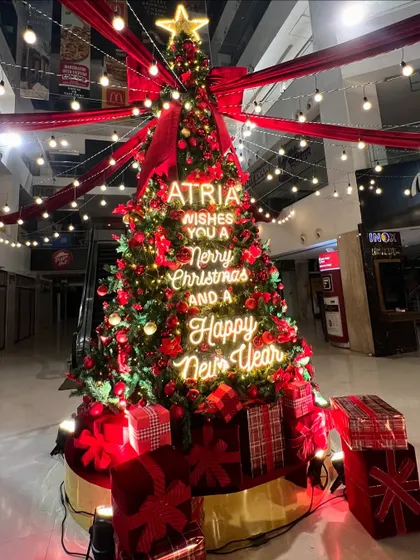 For the Atria Mall, I designed a festive installation that was all about big impact. This towering Christmas tree became the centerpiece, featuring custom neon signage with holiday wishes, classic red and gold ornaments, and dramatic overhead lighting to draw in shoppers and create a magical atmosphere.