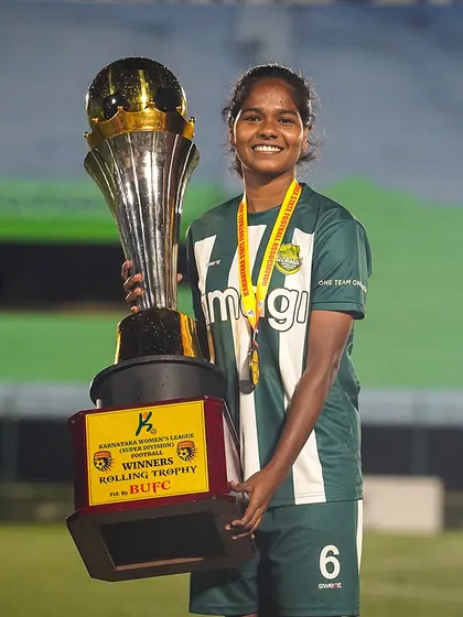 A smile of a champion. One of our players proudly holds the massive Winners Rolling Trophy, a symbol of her team's hard-earned victory in the league.