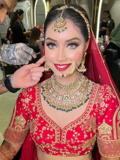 A behind-the-scenes shot of the bride getting her earrings fixed, giving a closer look at the beautiful craftsmanship.