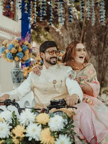 A joyful shot of the couple on a decorated vehicle, their smiles and laughter capturing the fun-loving spirit of their celebration.