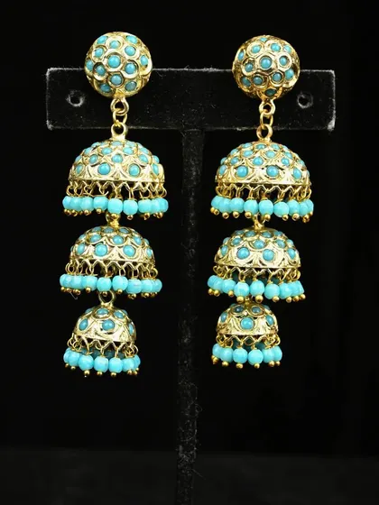 For a pop of color, these three-tiered jhumkas are perfect. Each gold-toned dome is adorned with bright turquoise beads, creating a playful and eye-catching accessory.
