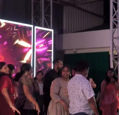 The guests are enjoying the music and visuals at the cocktail party.