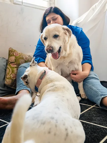 A mom snuggles with her two Labradors, showing the love she has for her fur kids.