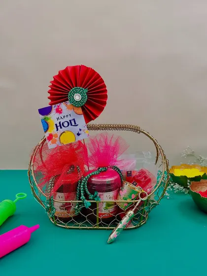 This small gold wire basket is perfect for a personal Holi gift. It contains jars of thandai mix or snacks, along with a pichkari and a packet of gulal.