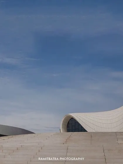 An ultra-wide shot showing the immense scale of the modern architecture in Baku, with the couple as a small but central focus.