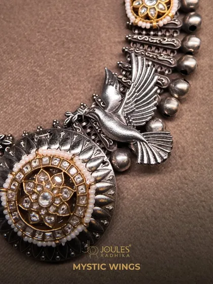 A detailed shot of the Mystic Wings choker, highlighting the craftsmanship of the silver bird and the polki medallion.