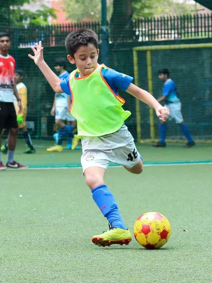 A young player from our youth program demonstrates perfect form, striking the ball with power and precision during a training session. We focus on developing strong technical fundamentals from an early age.