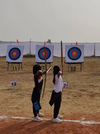 Young archers at the state competition, demonstrating their shooting stance with traditional wooden bows.
