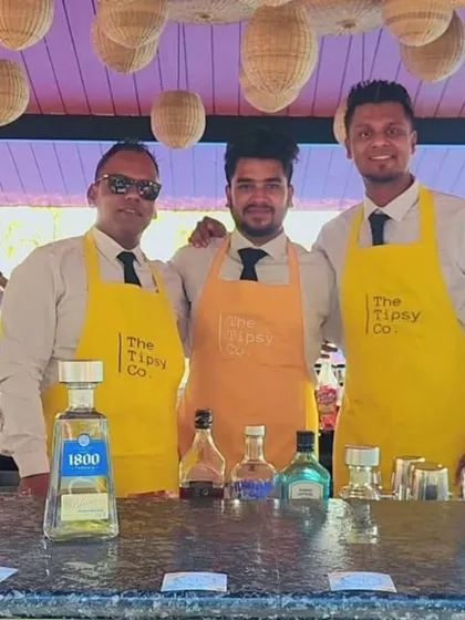 Three of our bartenders in bright yellow aprons, perfect for a sunny brunch event. We always dress to match the vibe of the celebration.