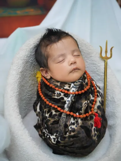 A close-up portrait from the 'Little Shiva' session, focusing on the baby's serene face and the carefully placed props.