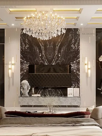A different take on a neoclassical bedroom, this one features a dramatic black marble wall behind the TV. The crystal chandelier and classical columns add to the grand, palatial feel of the room.