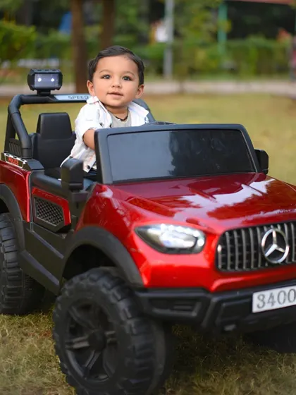 This little guy is ready to roll in his shiny red toy jeep. A fun prop for a kid's outdoor portrait session.