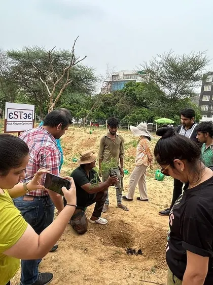 Our rewilding expert demonstrates the correct planting technique to the attentive volunteers from Estee Advisors.