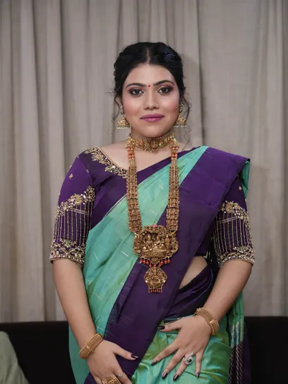 This full-length portrait shows how the makeup, hair, and outfit come together for a truly stunning South Indian glam look.
