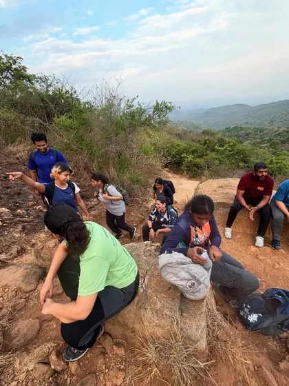 A group taking a short break on a rocky trail. Our leaders use these moments to share tips, check on everyone's well-being, and point out interesting features of the landscape.