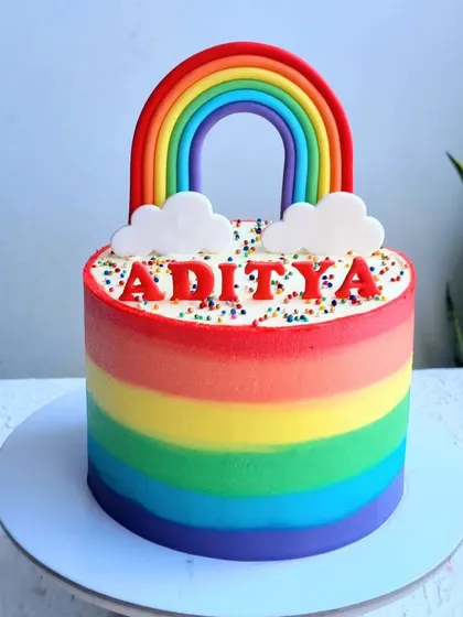 A vibrant rainbow cake with buttercream stripes. I show you how to create smooth, blended stripes and a perfect fondant rainbow topper.