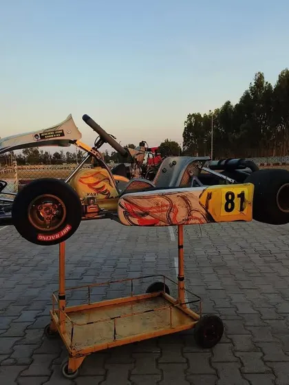 A professional Rotax kart, raised on its stand, ready for adjustments between test runs. Our technical team works closely with drivers to optimize the chassis and engine performance.
