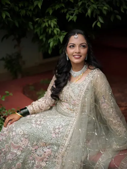 This bride's reception look features a sparkling lehenga paired with soft, romantic makeup and loose curls. The focus is on radiant skin and eyes that shine.