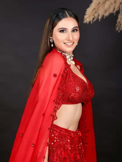 A side profile of the same red lehenga, showing the fit and flow of the outfit. This angle is great for e-commerce listings to display the garment's structure.