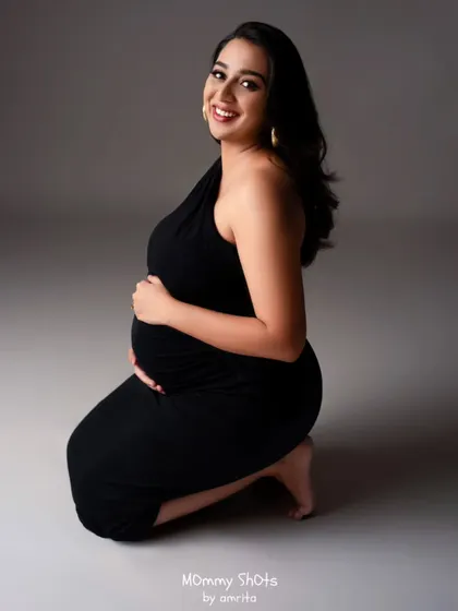 A beautiful and tender moment captured during the maternity shoot. The makeup is soft and glowing, highlighting the joy of expecting.