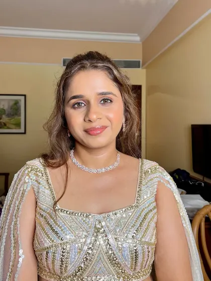 A front-facing view of this glamorous Sangeet look. The makeup is balanced with a natural, dewy base to keep the focus on her sparkling eyes.