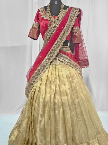 This elegant half saree in cream and red is a classic choice for traditional events or photoshoots.