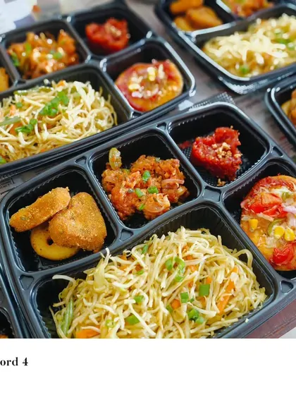 A special Valentine's Day lunch order packed with variety. Each box contains veg hakka noodles, mini pizzas, gobi manchurian, and potato nuggets, offering a full and festive meal.