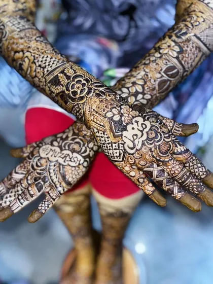 A crossed-hands view showing both names, "Muzna" and "Muzassir," in this personalized Nikah bridal design.