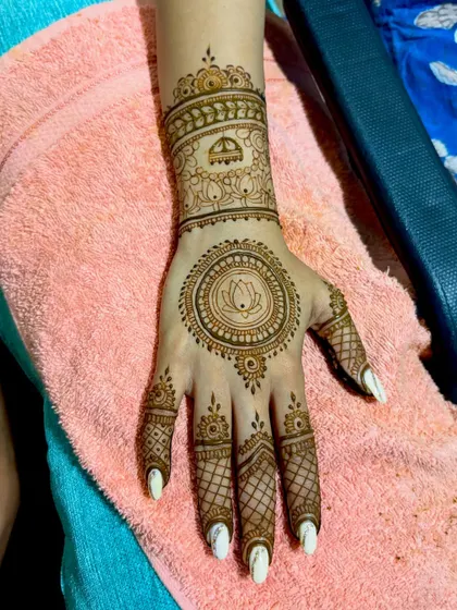 A single-hand view of Divya's wedding mehendi, focusing on the central lotus mandala.
