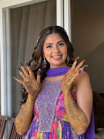 Showing off her beautiful henna. For her Mehendi, we went with a very natural makeup look and a fun, colorful outfit.