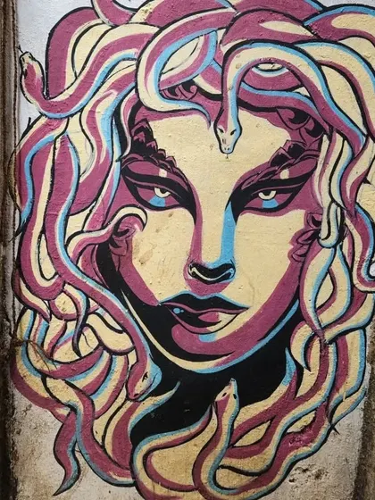 A striking mural of Medusa with colorful, snake-like hair. This piece brings a touch of Greek mythology to the streets of Mumbai, rendered in a bold, graphic style.