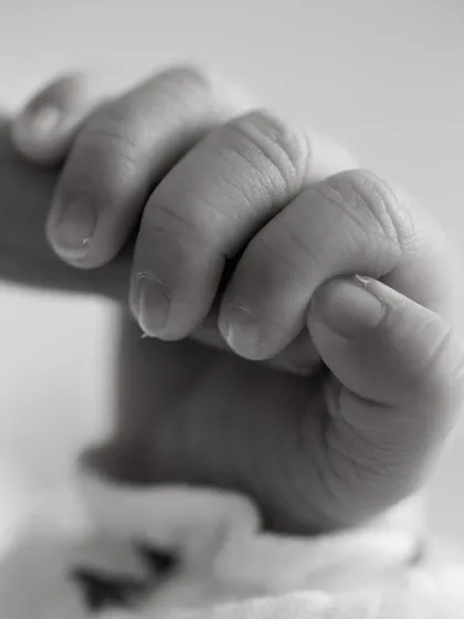 The tiniest details hold the biggest love. This close-up of a newborn's hand gripping a parent's finger is a powerful reminder of how small they once were, a precious memory to cherish.