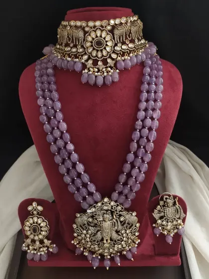 This Victorian set combines a choker with an elephant motif and a long necklace with a Krishna pendant. The lavender beads give it a contemporary feel.