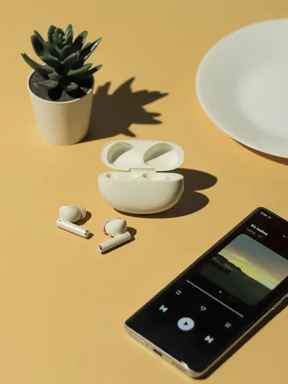 A flatlay showing the realme earbuds next to a phone playing music, directly communicating the product's function.