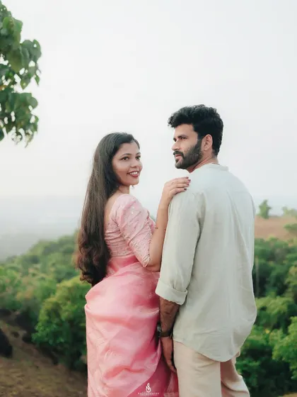 A lovely pose overlooking a valley of green hills. This shot combines an intimate moment with a grand, scenic landscape.