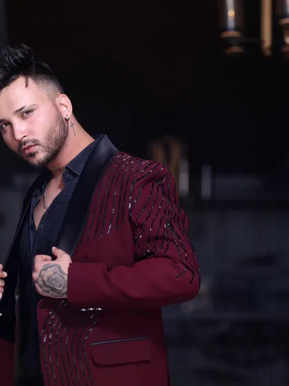 A closer look at the maroon tuxedo jacket, showing the detail of the sequin work and the sharp cut of the lapels.