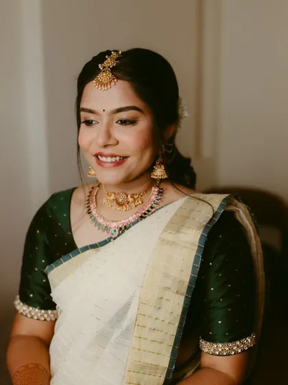 A beautiful, happy portrait of a bride-to-be during her engagement shoot. Her simple white and green saree and joyful smile are radiant.