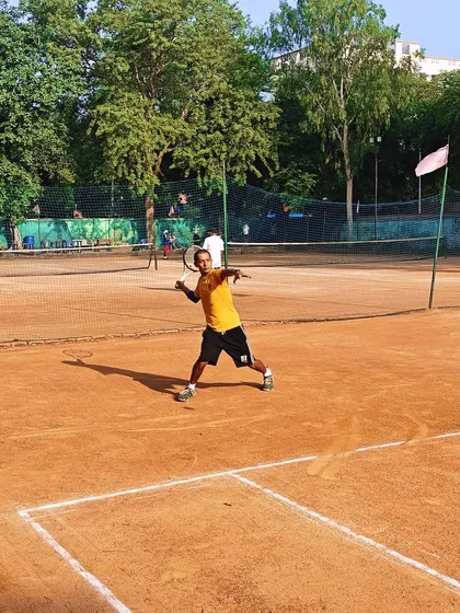 An action shot of a player hitting a powerful forehand during a match on a clay court. This demonstrates the kind of offensive tennis we encourage.