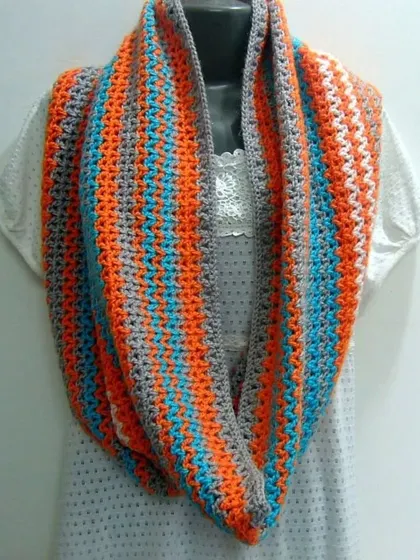 This V-stitch infinity scarf uses a vibrant mix of orange, blue, and grey. The simple stitch allows the colors to create a bold, striped effect.