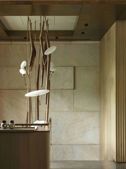 A detail of the Klove Grasshopper light against the textured stone wall. This composition highlights our approach of layering light, texture, and form to create spaces with depth and elegance.