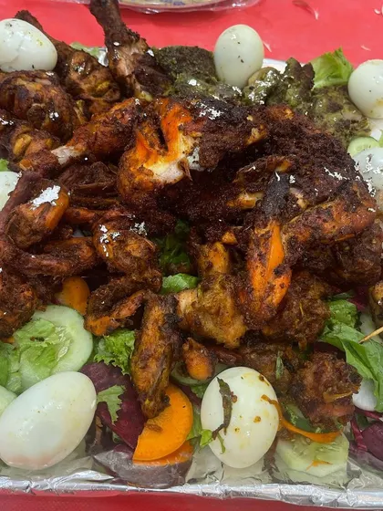 A grand platter of our non-veg starters. This includes tandoori chicken, hariyali kebabs, and fried chicken pieces, garnished with boiled eggs and fresh salad for a stunning presentation.