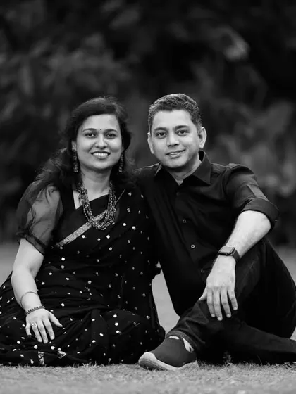 A quiet moment between a couple, seated on the grass in a park. This black and white portrait emphasizes their connection and the peaceful atmosphere.