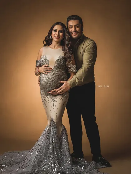 A glamorous maternity portrait. The mother-to-be shines in a stunning sequined gown, creating a dramatic and unforgettable image of her pregnancy.