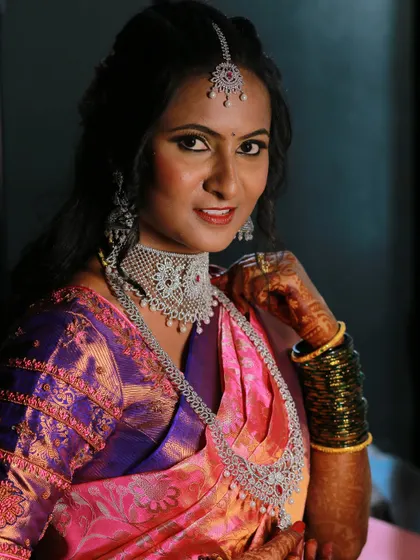 A beautiful portrait of a bride adjusting her necklace, showcasing her diamond jewelry set.