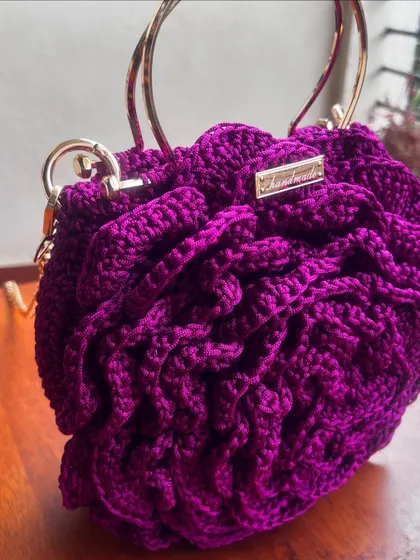 A close-up of the side of the deep purple Rose Bag, showing the secure attachment of the handle and chain.